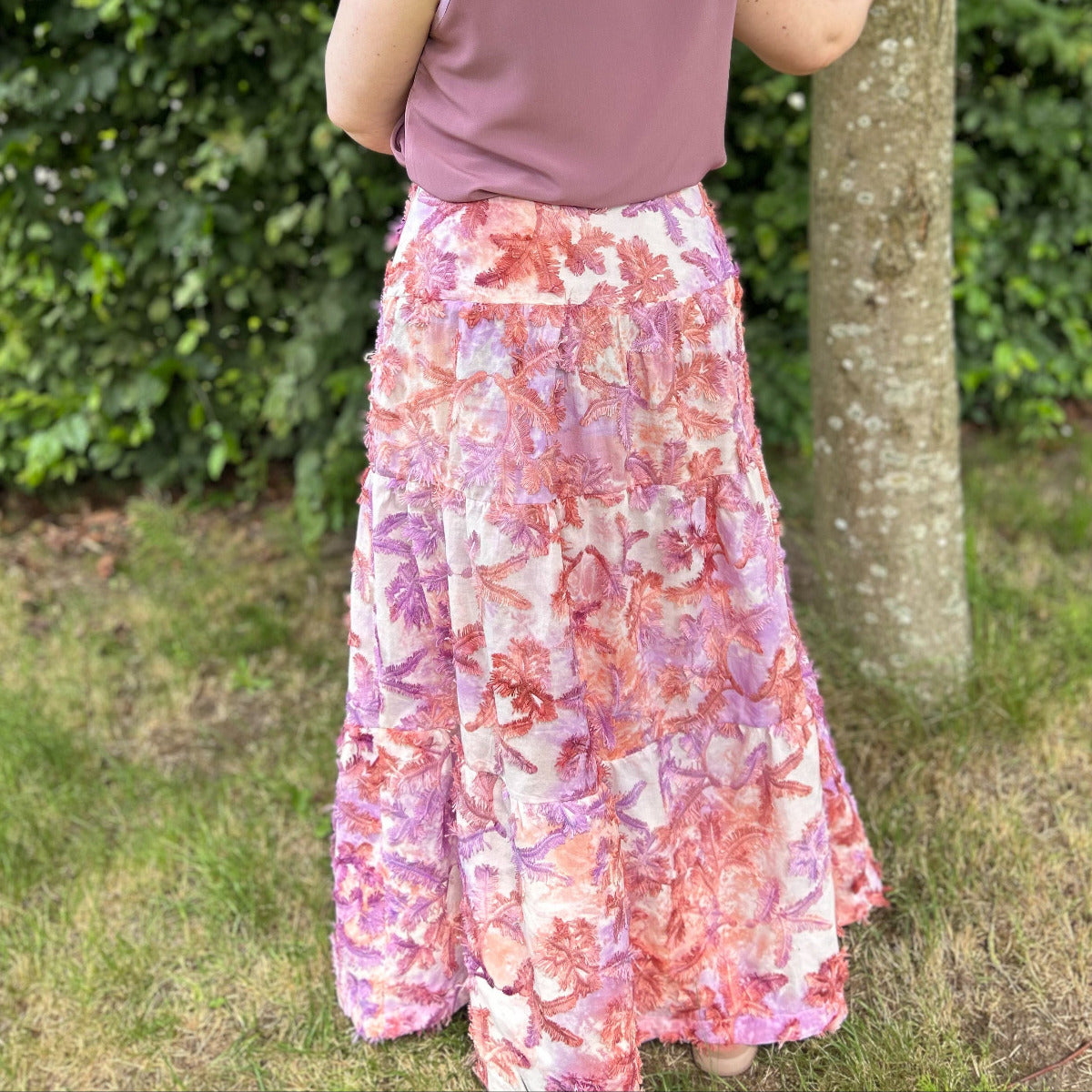 Boho Maxi Skirt von hinten in einem sommerlichen Stoff mit roten und lilafarbenen Pflanzen.