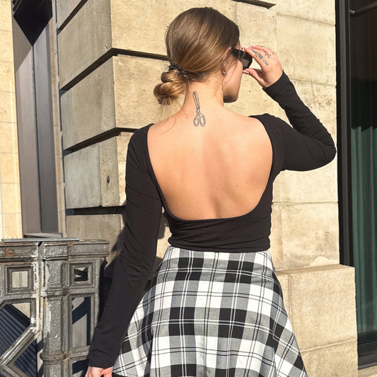 Rückenfreies Langarmshirt in schwarz von hinten und getragen zu kariertem easy skirt.