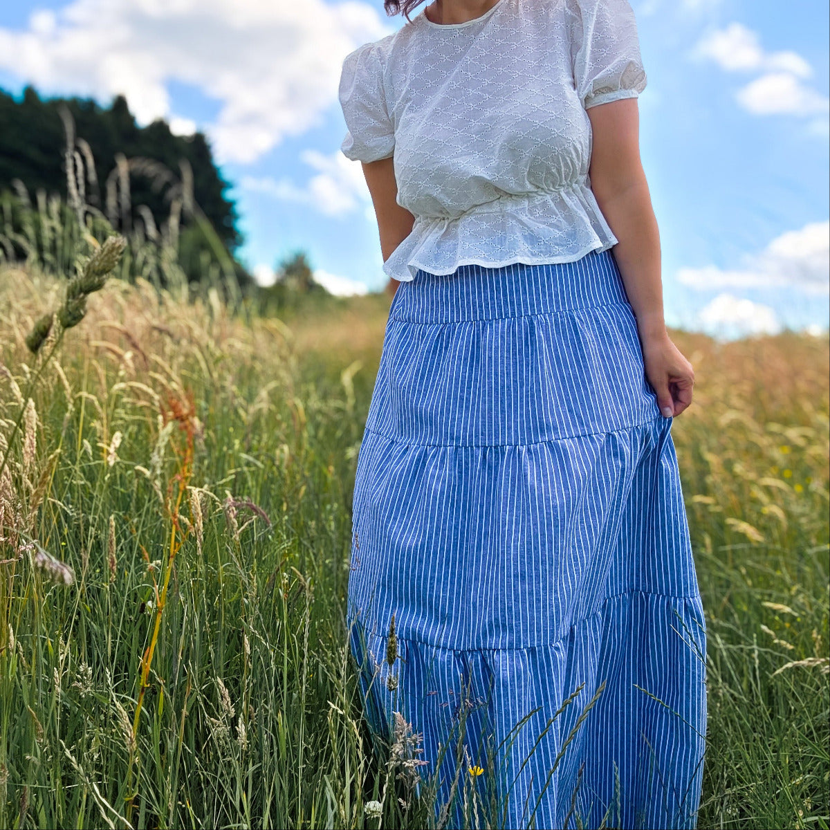 Boho Maxi Skirt in blau weiß gesreift von vorne, fotografiert im Kornfeld. 