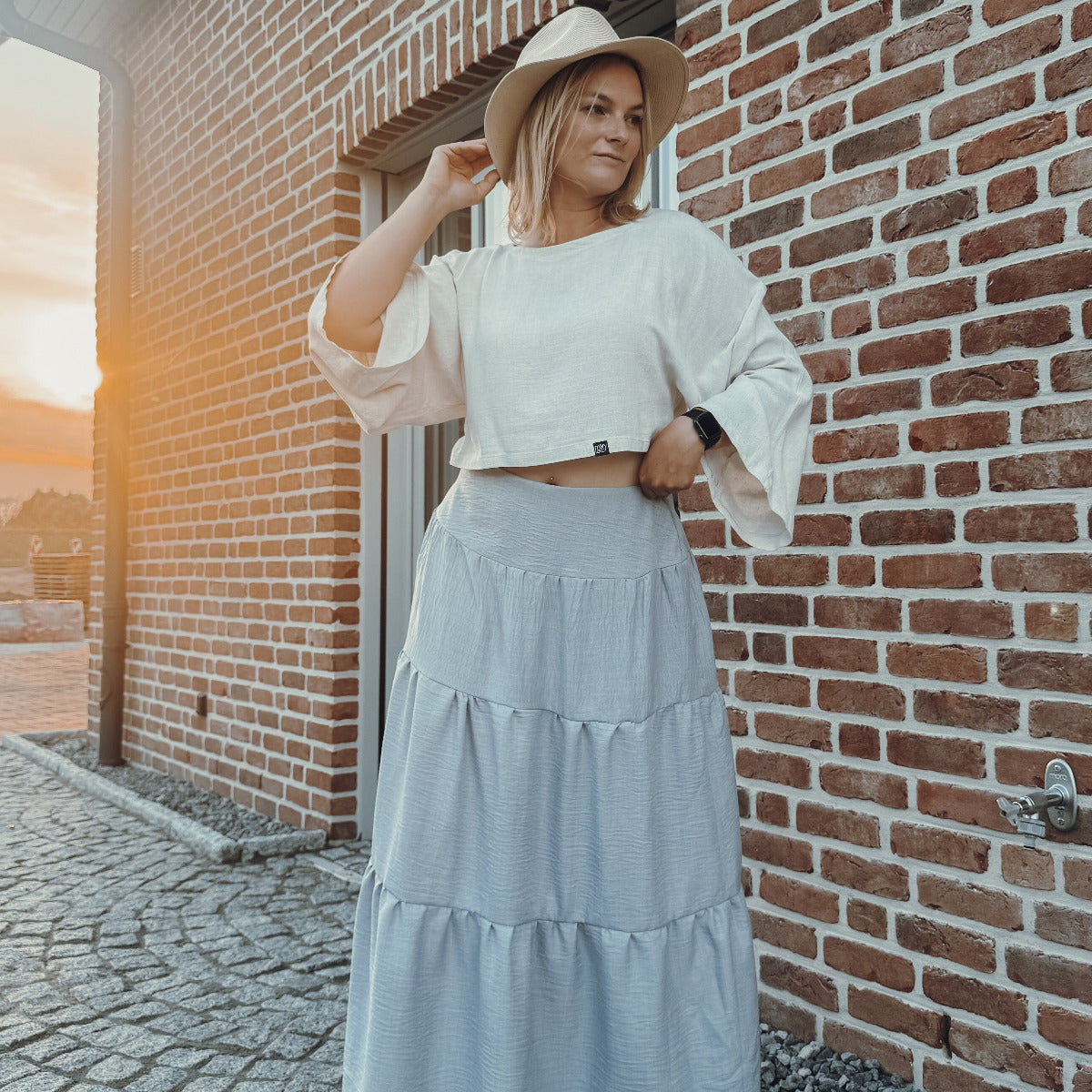 Grauer Boho Maxi Skirt von vorne, sommerlich gestylt mit Hut und Boho Bluse.