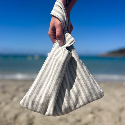 Grau weiß gestreifte Knot bag am Strand.