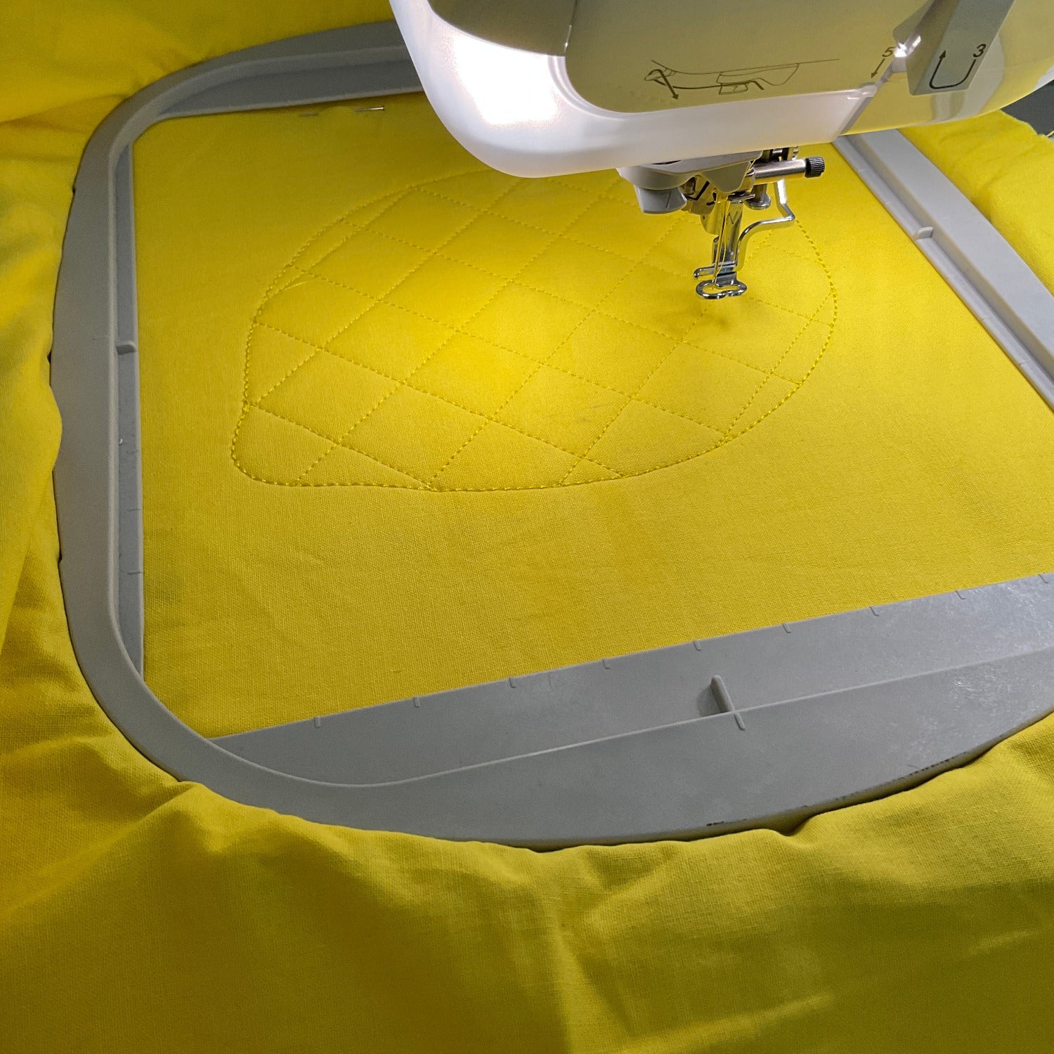 Topflappen Zitrone im Stickrahmen eingespannt und die Stickmaschine ist fertig mit den Stepprauten.